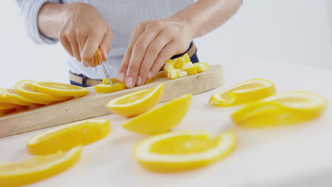 mid-section of woman cutting fruits on chopping board