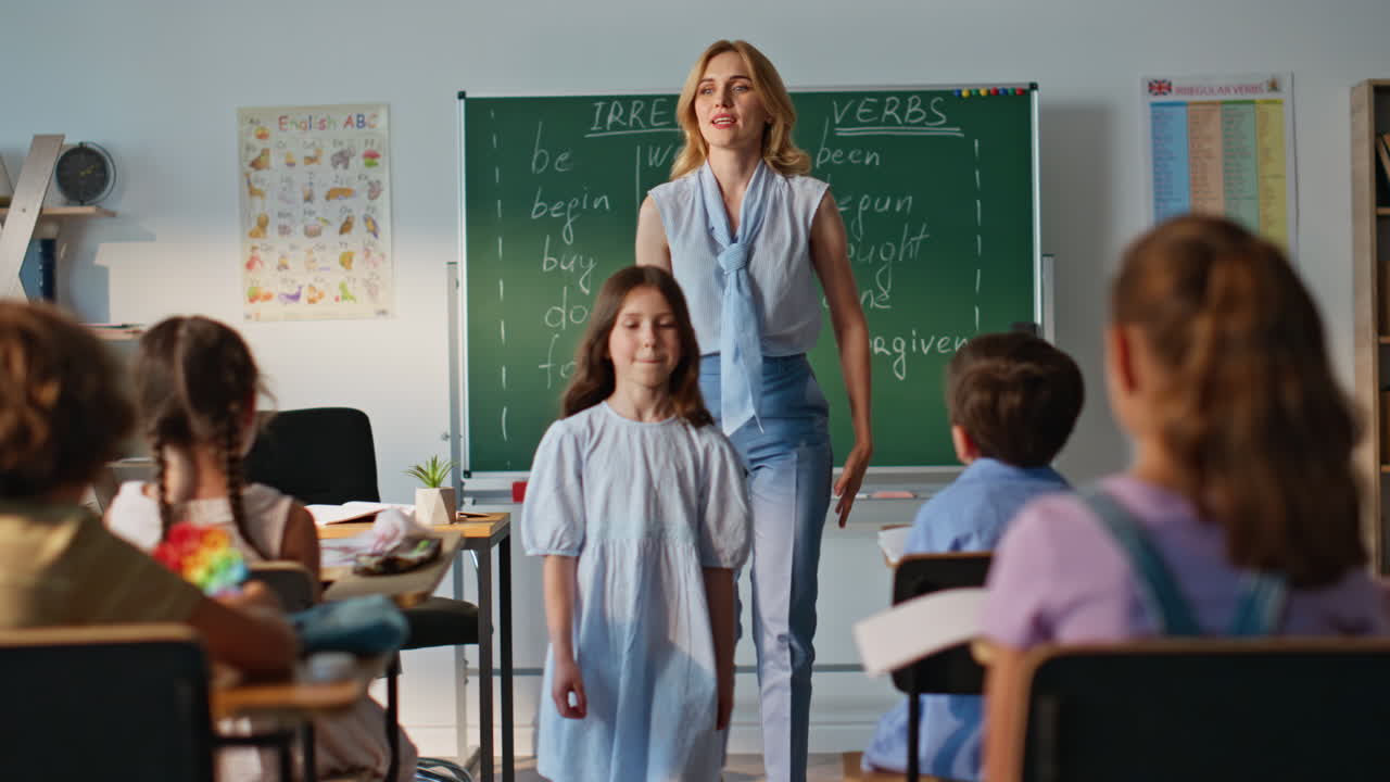 Woman asking schoolgirl lesson teaching elementary school class. Little pupil