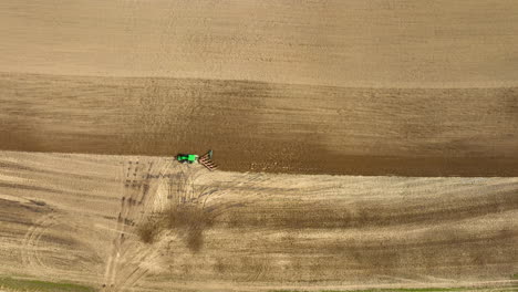 green tractor ploughing field