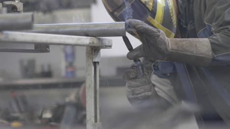 blacksmith welder in protective mask welding metal - close up, slider right