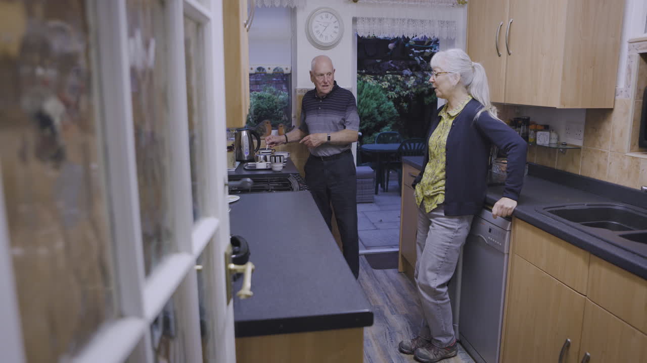 An older couple chatting in their kitchen