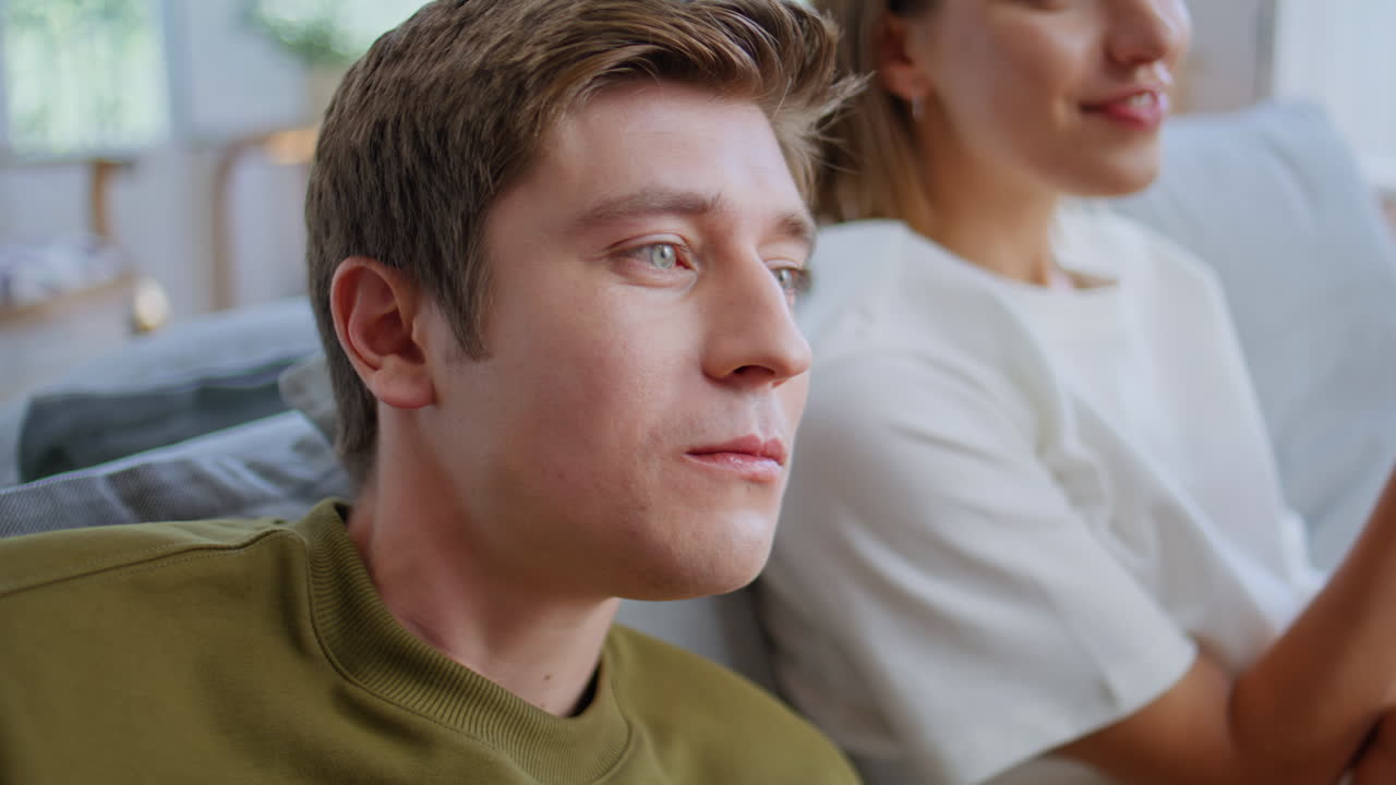 Happy woman feeding boyfriend with pizza at room closeup. Friends watching tv