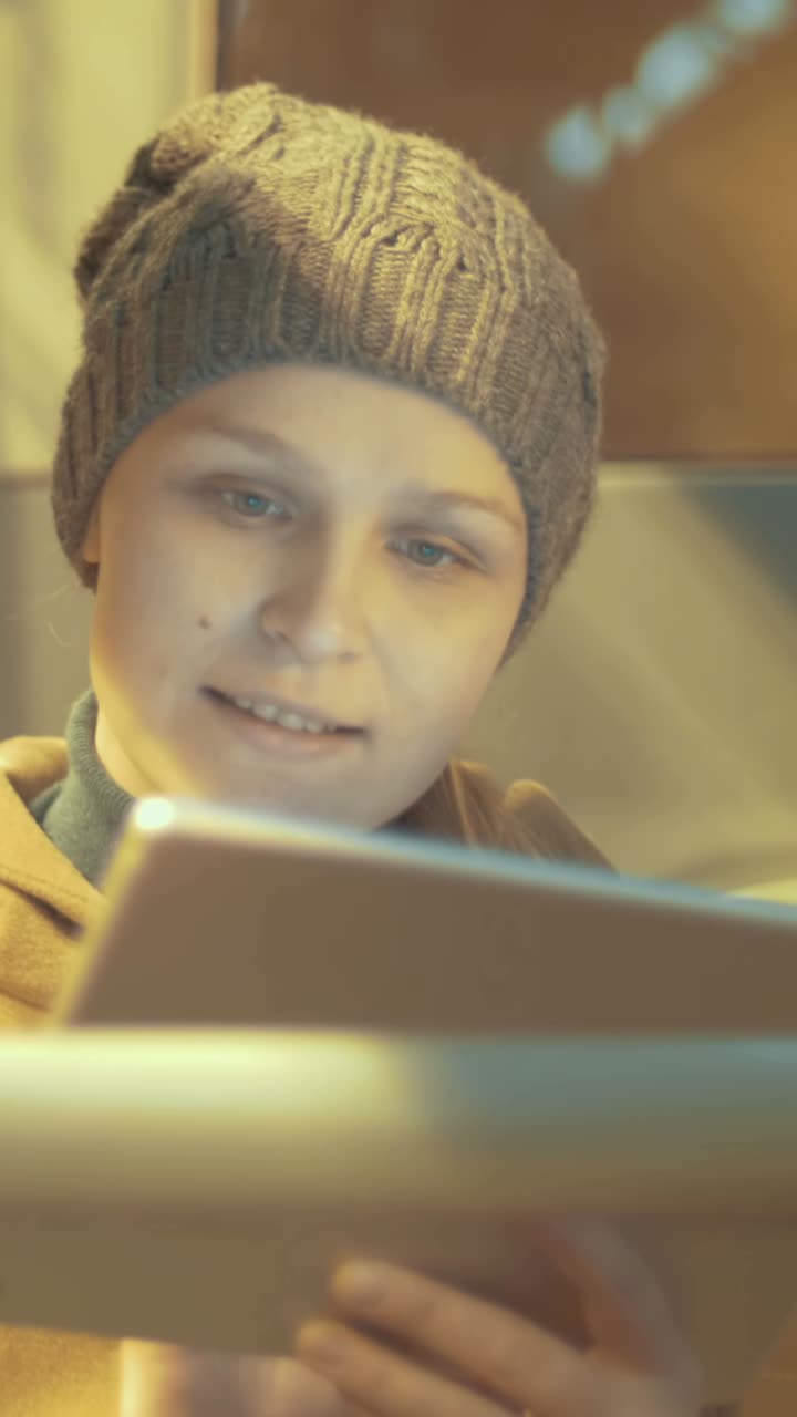 Woman using tablet with a knitted hat