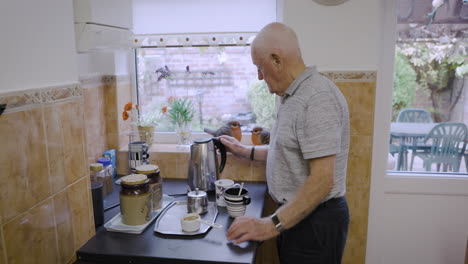 senior man making coffee in his kitchen