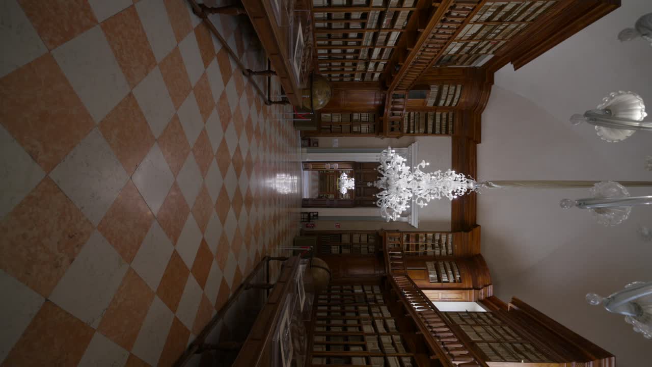 biblioteca teresiana mantova | antigua biblioteca con lámparas de cristal colgadas