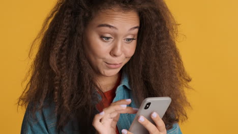 caucasian curly haired woman scrolling on smartphone.