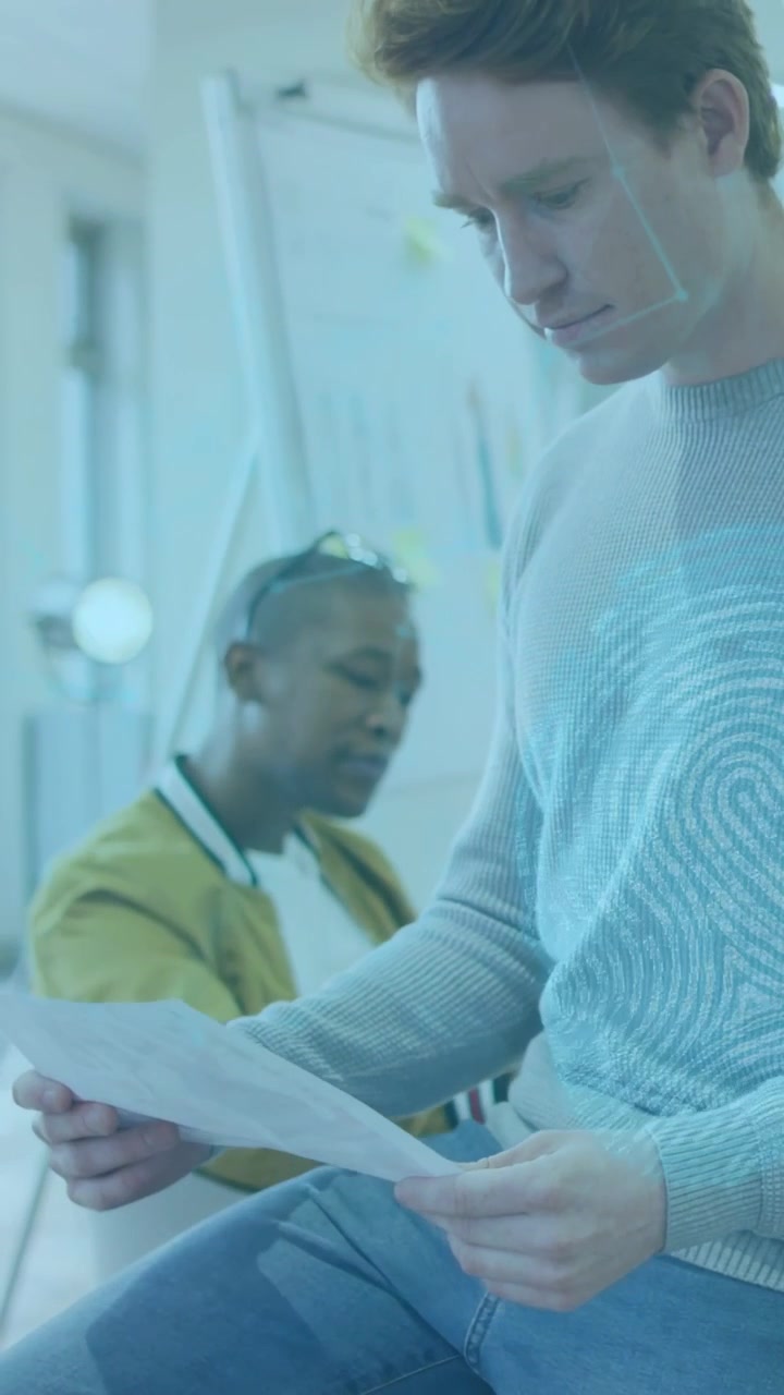 Vertical video: Man holding paper sheet reading for business review while blue overlay marking page