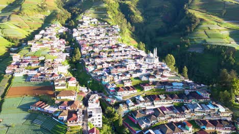 Filmische-Drohnenaufnahme-Mit-Farbenfrohen-Gebäuden-Namens-Nepal-Van-Java-Auf-Einem-Berg-Während-Der-Sonnenuntergangszeit-In-Indonesien