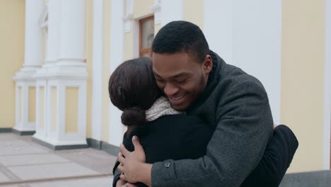 couple hugging outside building