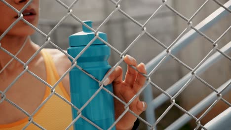 young athletic woman with water bottle resting after workout