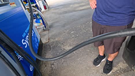 man refueling car at gas station in piedmont