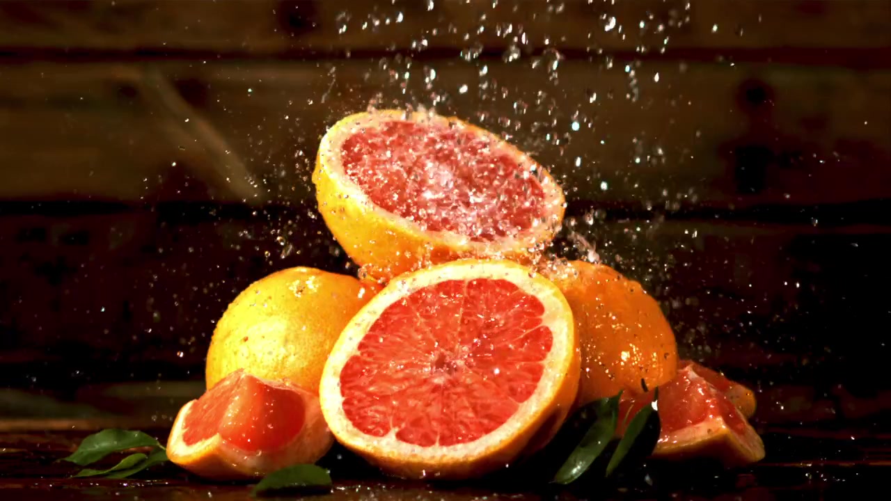 Schizzi d'acqua su pompelmi rossi freschi al rallentatore