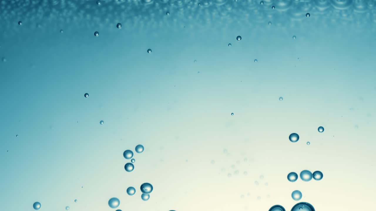 Many water bubbles in blue water close up, abstract water wave with bubbles in slow motion.