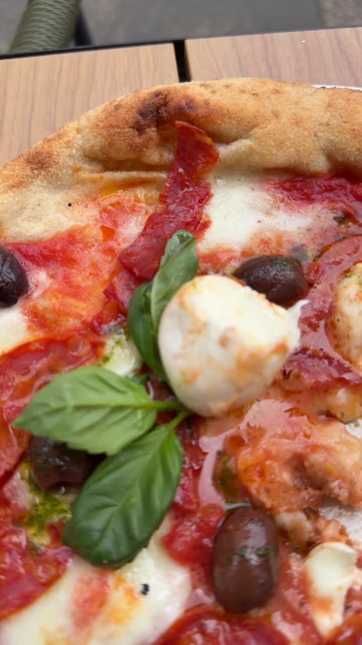 Deliziosa pizza napoletana con salame piccante, mozzarella, olive e basilico fresco