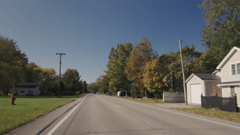 Drive-through-a-small-American-town,-view-from-the-back-window-of-the-car-to-a-typical-street