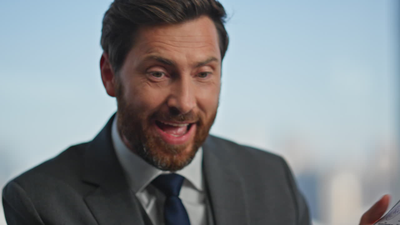 Smiling boss talking online closeup. Positive man holding successful contract