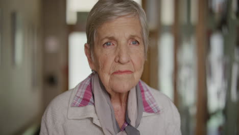 portrait of elderly caucasian woman standing looking pensive contemplative thinking memories in retirement home background