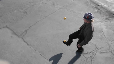 a man juggles two balls with his feet