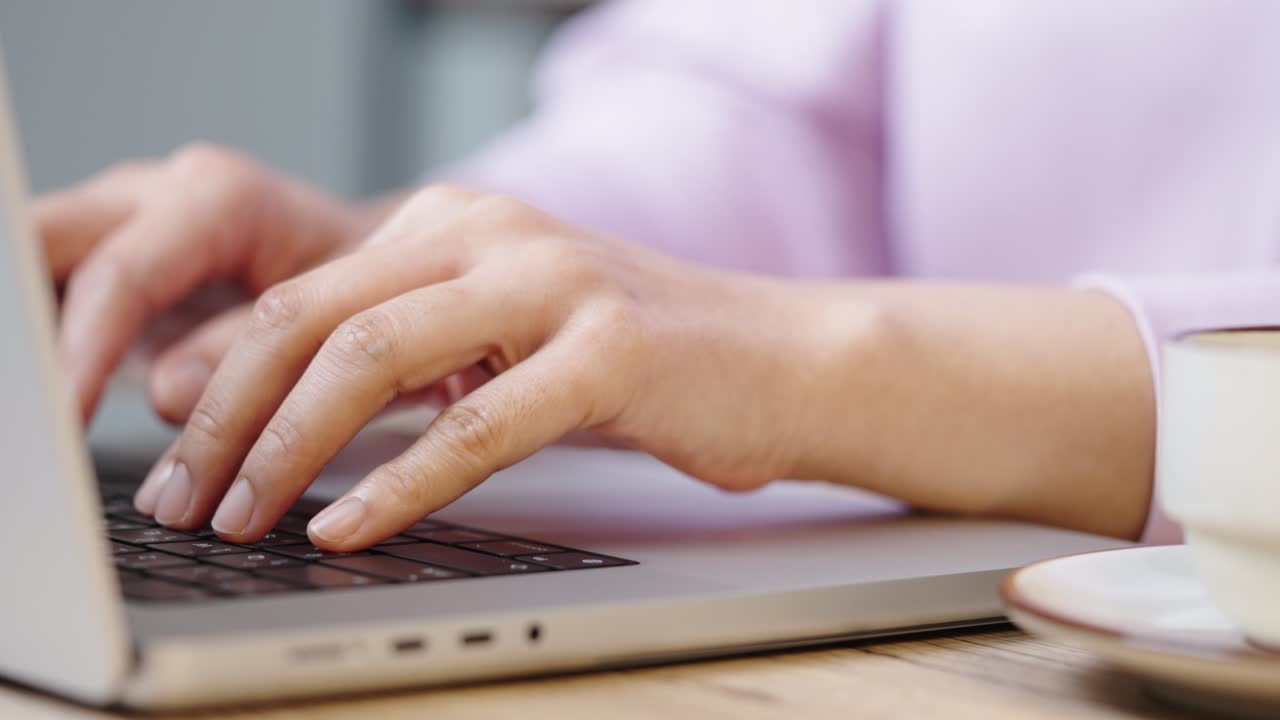 close up hand of a business woman typing keyboard laptop computer on desk office