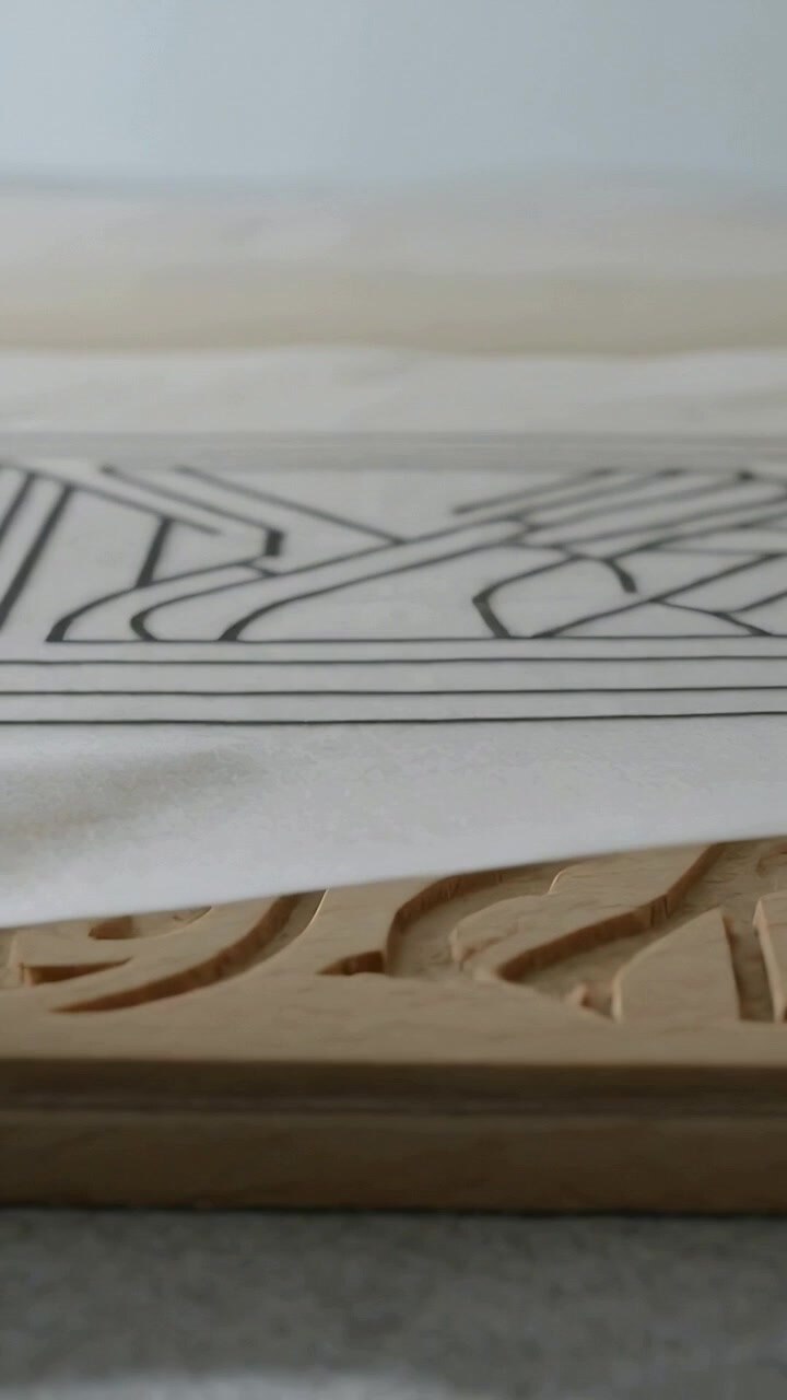 Vertical video: Sliding printed sheet revealing carved wood block on craft table, exposing cutouts