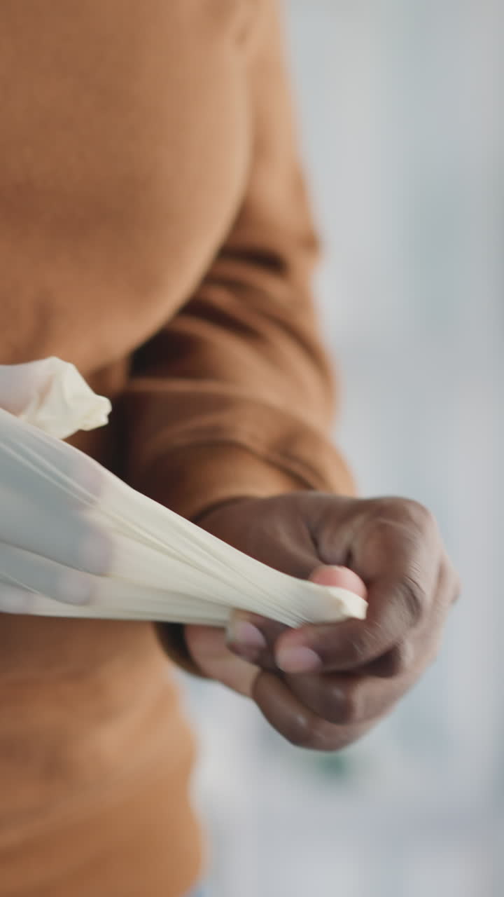 mujer afroamericana se quita el guante de goma después del procedimiento arrojando a la basura en un fondo borroso. persona femenina se ocupa de la higiene de cerca