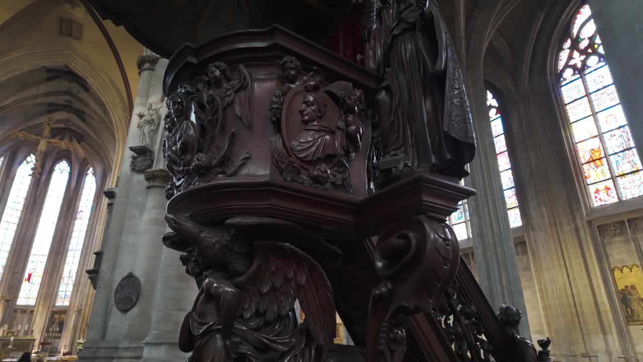 Ornate wooden pulpit in a Gothic church with stained glass, Brussels, Belgium