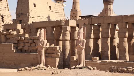 panning shot of the ruins of ancient temple of luxor with a mosque and minaret