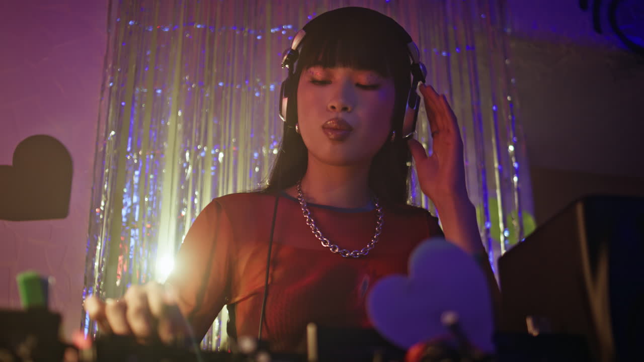 Skilled DJ listening headphones music intently on nightclub scene closeup