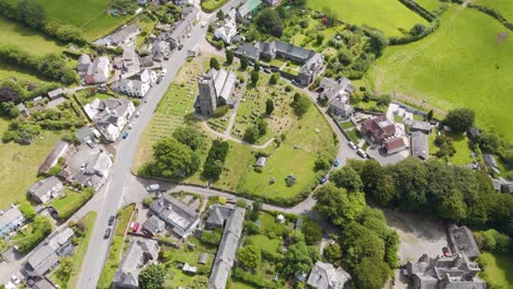 aerial view of a quaint village with a historic church and graveyard