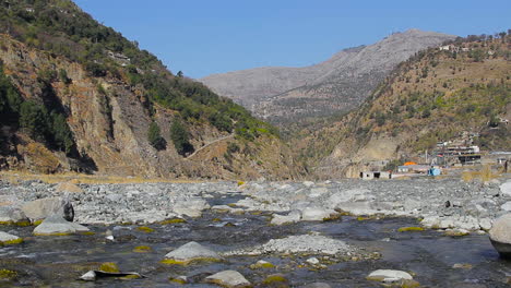 river streaming to the town in the mountains with a beautiful blue sky view, streets, living, houses and forest on the other mountains