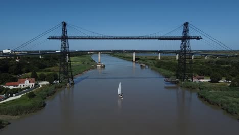 un velero cruzando bajo el puente transportador de rochefort sur mer, francia
