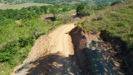 camino de tierra en construcción con una excavadora y gente trabajando, camino en las montañas