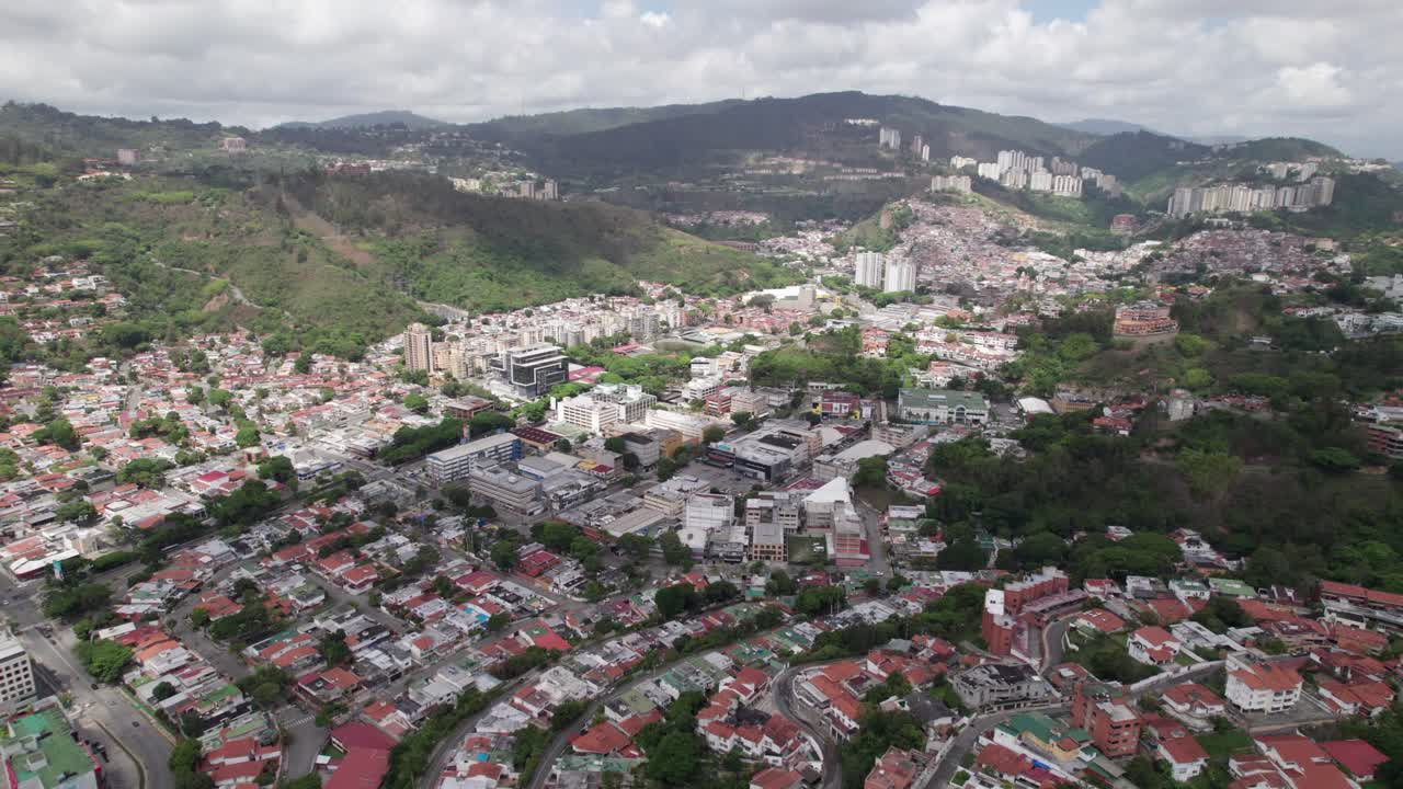 Aerial traveling over Caracas showing movement past trees, rooftops and urban grid