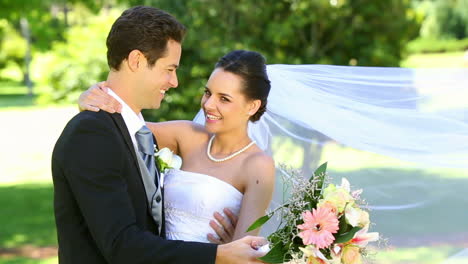 happy newlyweds dancing in the park