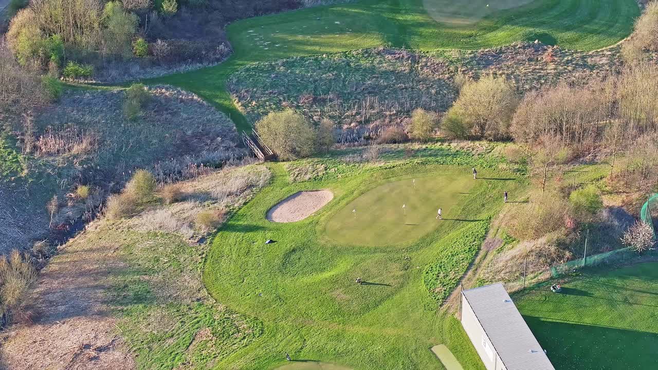Aerial view of golfers on putting green at Waterfront Golf Club in morning light, Rotherham, South Yorkshire, UK