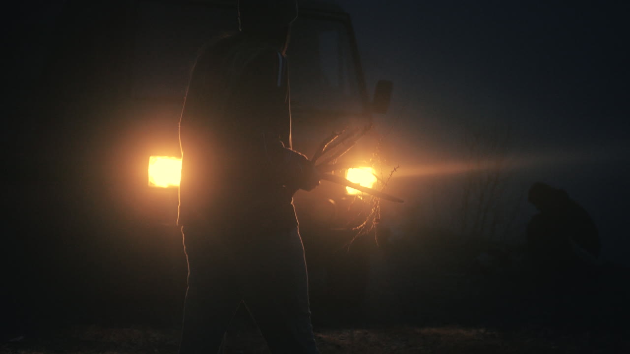 Person Walking at Night with Branches