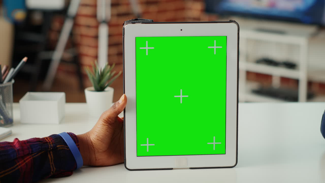 Young woman vertically holding device with green screen