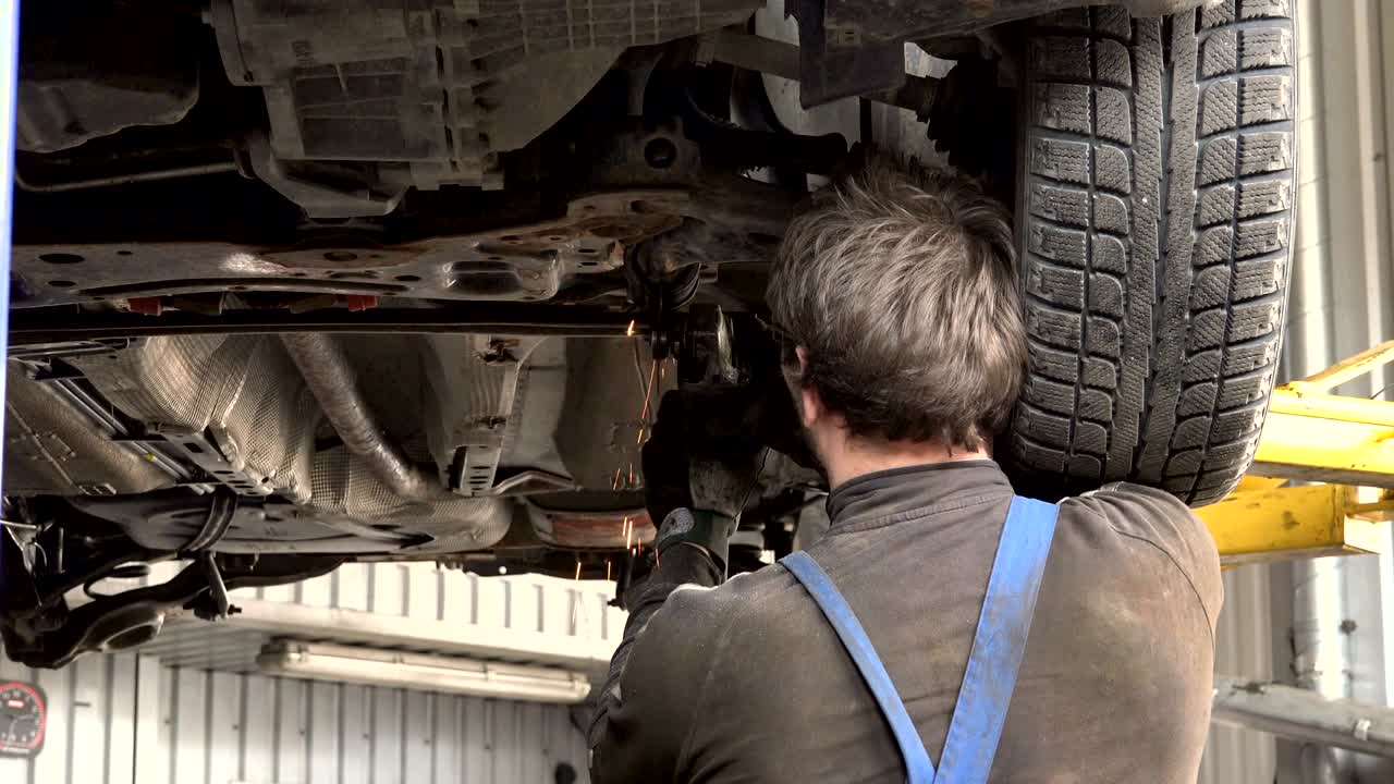 글 그린더를 가진 자동차 수리공. 반이는 불꽃이 다가오고 있습니다.