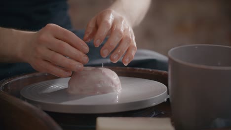 potter wets piece of colored clay on the potter's wheel for sculpting ceramics in nerikomi style, neriage ceramics, potter makes ceramics in slow motion, 4k 60p prores hq 10 bit