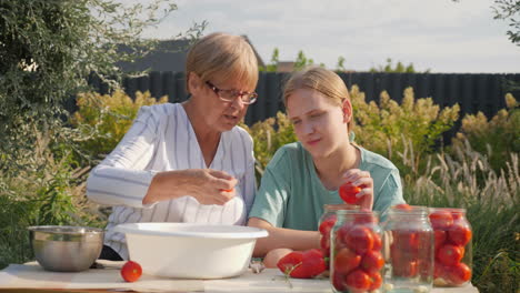 abuela y nieta conservando tomates