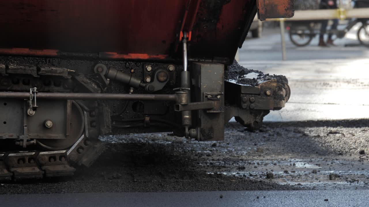 Detailed view of asphalt paving machine in urban environment on a sunny day