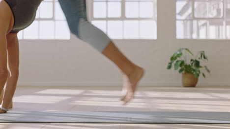 healthy yoga woman practicing standing forward bend pose enjoying fitness lifestyle exercising in studio stretching beautiful body training on exercise mat at sunrise