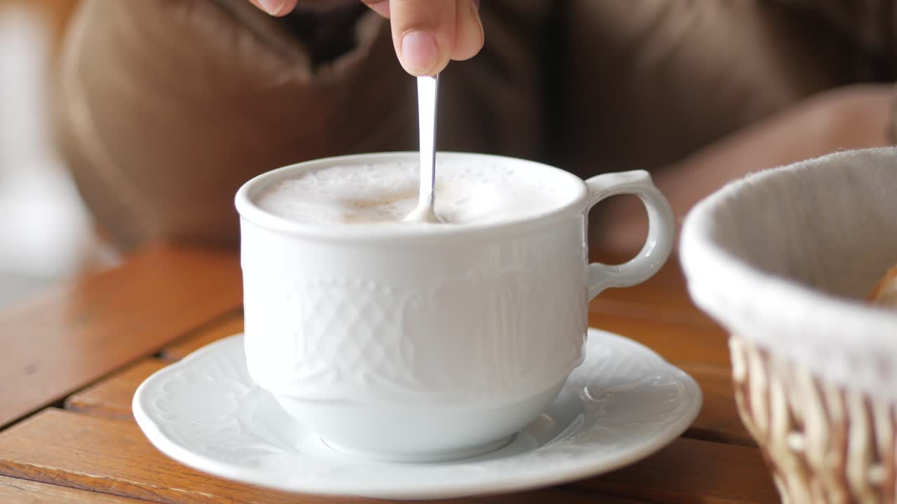 Person stirring coffee with a spoon