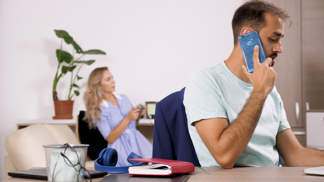 Office Scene with Man on Phone and Woman in Background