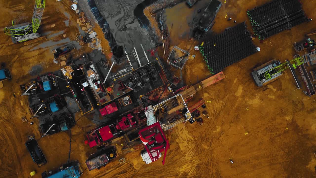 кинематографические беспилотные кадры структуры оборудования наземной буровой установки для разведки и добычи нефти посреди джунглей в окружении пальмовых деревьев во время заката и высокой цены на нефть