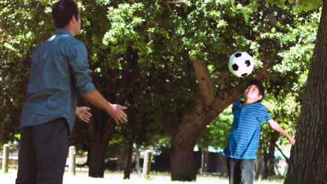 Boy-playing-soccer-in-slow-motion-with-an-adult