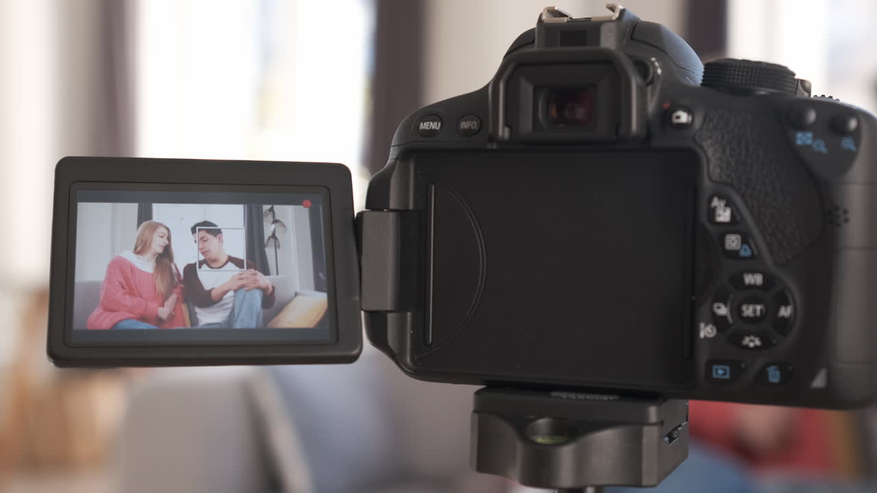 Young video bloggers having fun together and creating content while making a video at home