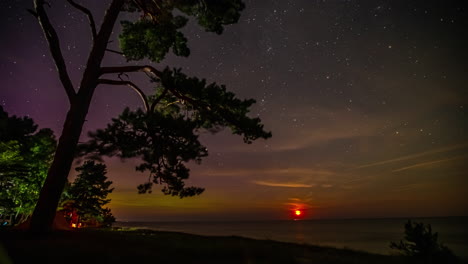 Zeitrafferaufnahme-Von-Sternen-Der-Milchstraße-Zusammen-Mit-Aurora,-Die-Bei-Sonnenaufgang-über-Dem-Meer-Sichtbar-Ist