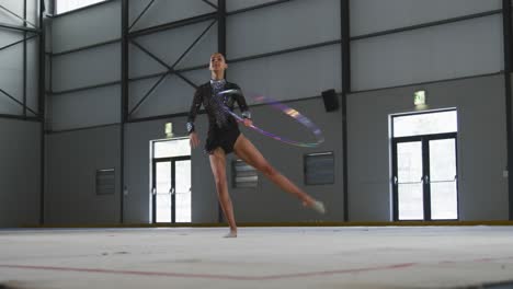 Female-gymnast-performing-at-sports-hall