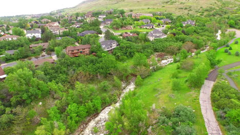 beautiful drone aerial of a trail and river at the edge of the suburbs near some mountains